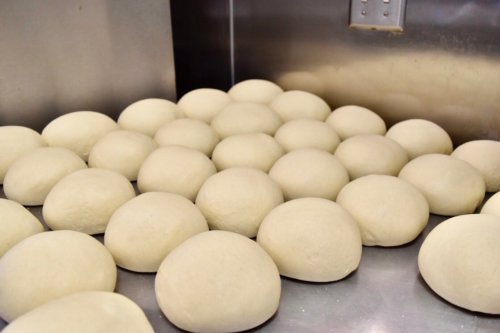 Photo of dough balls rolled up and placed next to eachother